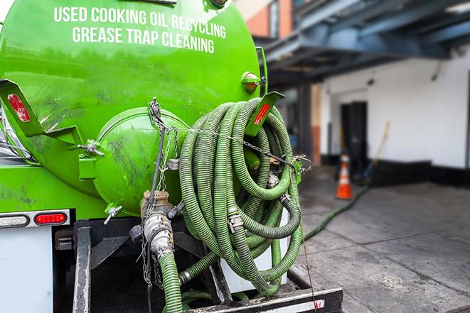 a grease trap pumping service in action at a commercial building in Carlsbad, CA